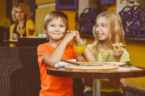 Happy or satisfied boy width girl eating pizza and drinking juice Stock Photos