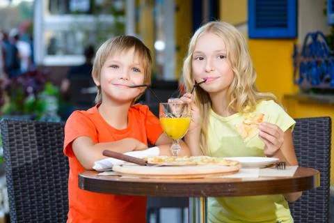 Happy or satisfied boy width girl eating pizza and drinking juice Stock Photos