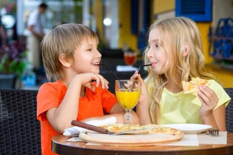 Happy or satisfied boy width girl eating pizza and drinking juice Stock Photos