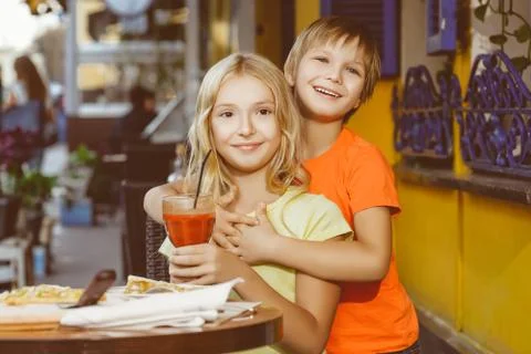 Happy or satisfied boy width girl eating pizza and drinking juice Stock Photos