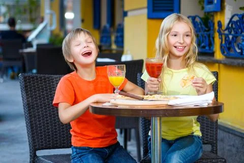 Happy or satisfied boy width girl eating pizza and drinking juice Stock Photos