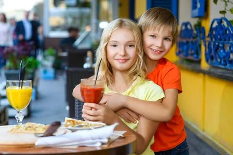 Happy or satisfied boy width girl eating pizza and drinking juice Stock Photos