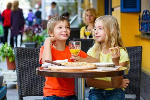 Happy or satisfied boy width girl eating pizza and drinking juice Stock Photos