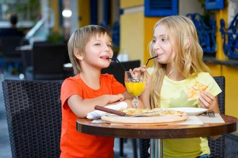 Happy or satisfied boy width girl eating pizza and drinking juice Stock Photos