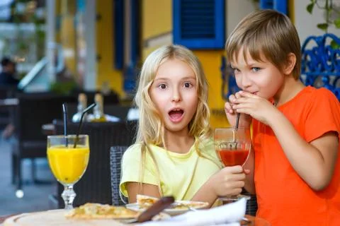 Happy or satisfied boy width girl eating pizza and drinking juice Stock Photos