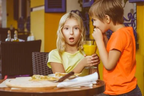 Happy or satisfied boy width girl eating pizza and drinking juice Stock Photos