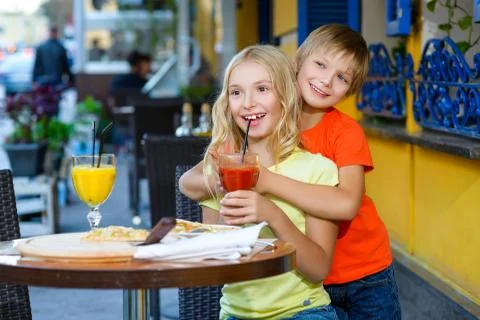 Happy or satisfied boy width girl eating pizza and drinking juice Stock Photos
