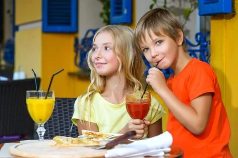 Happy or satisfied boy width girl eating pizza and drinking juice Stock Photos