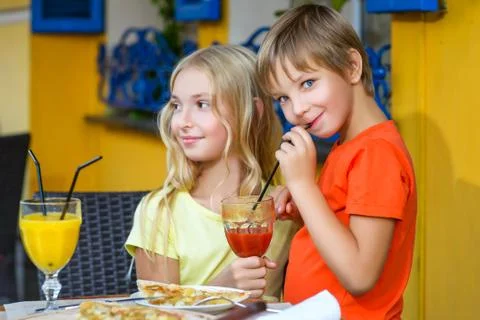 Happy or satisfied boy width girl eating pizza and drinking juice Stock Photos