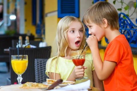 Happy or satisfied boy width girl eating pizza and drinking juice Stock Photos