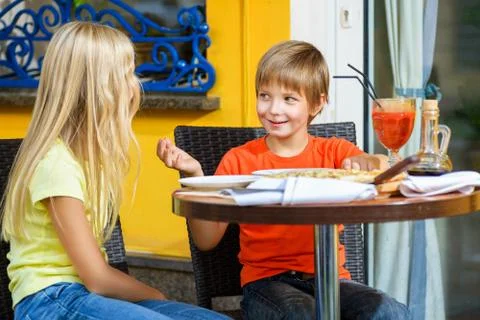 Happy or satisfied boy width girl eating pizza and drinking juice Stock Photos
