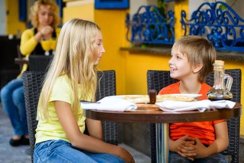 Happy or satisfied boy width girl eating pizza and drinking juice Stock Photos