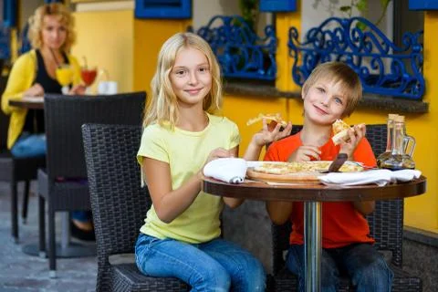 Happy or satisfied boy width girl eating pizza and drinking juice Stock Photos