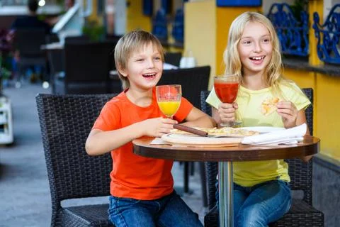 Happy or satisfied boy width girl eating pizza and drinking juice Foto stock