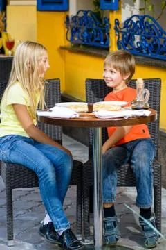 Happy or satisfied boy width girl eating pizza and drinking juice Stock Photos