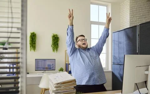 Happy overweight office worker dancing by computer, financial analysis success Stock Photos