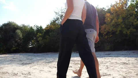 Happy pair going along coast at sunny day. Romantic couple holding hands of each Vídeo Stock 337723117