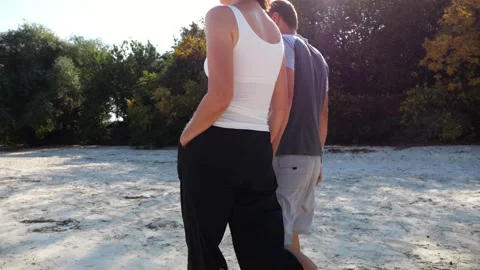 Happy pair going along coast at sunny day. Romantic couple holding hands of each Vídeo Stock 340903130