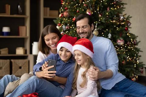 Happy parents and two little kids celebrating Christmas Stock Photos