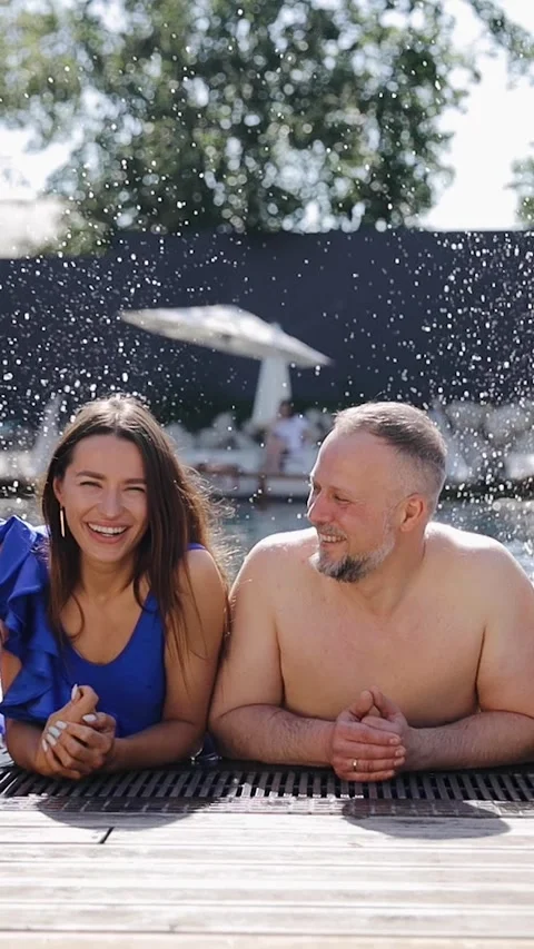 Happy parents having fun in the pool they are splashing water playing Stock Footage 267762055