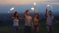 The happy people dancing with firework sticks on a city background. slow motion 4k or 4k+ Resolution