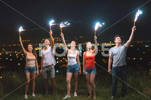 The happy people hold firework sticks. evening night time Stock Photos