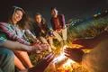 The happy people warming hands near the bonfire. night time Photo
