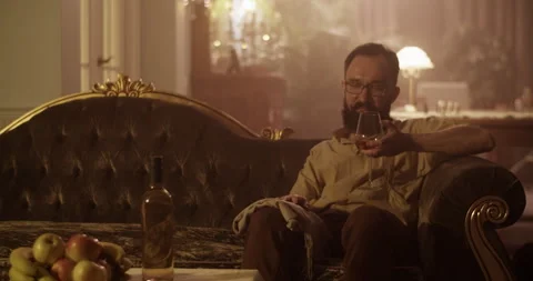 Happy perfumer drinking wine on couch Stock Footage 260987288