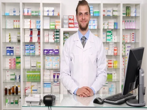 Happy Pharmacist Man Introducing Salute Showing Ok and Thumb Up Sign in Pharmacy Stock Footage 80264641