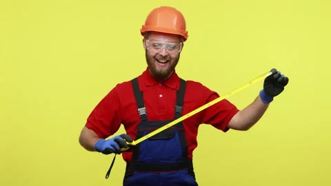 Happy positive builder standing with yellow measuret ape in hands, having funny Stock Footage 161437882