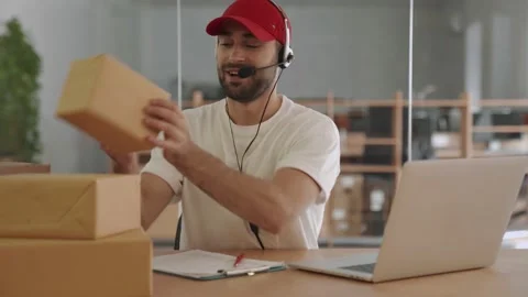 Happy post manager talking with client near parcel boxes in office Stock Footage 153843650