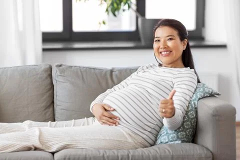 Happy pregnant asian woman showing thumbs up Stock Photos