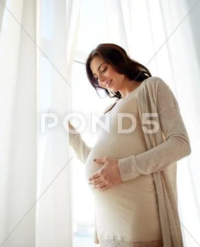 Happy pregnant woman with big tummy at home Stock Photos