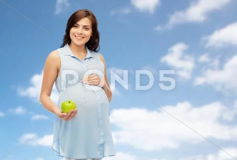 Happy pregnant woman holding green apple Stock Photos