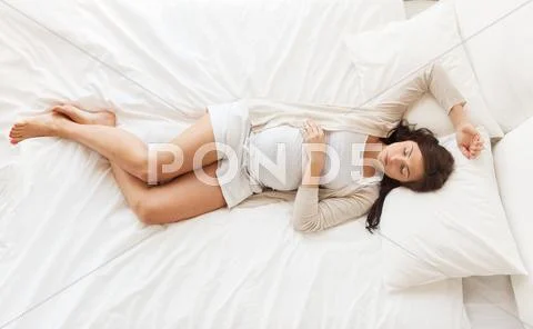 Happy pregnant woman sleeping in bed at home Stock Photos
