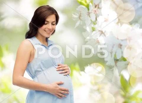Happy pregnant woman touching her big belly Stock Photos