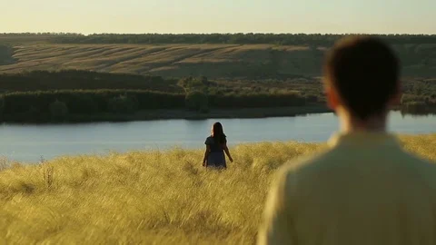 Happy pretty couple having fun outdoors through a field. Countryside. Young man Stock Footage 79073767