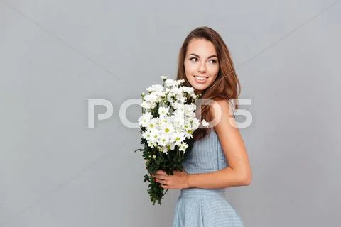 Happy pretty young woman with bouquet of flowers Stock Photos