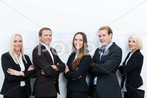 Happy professional team standing with folded arms Stock Photos