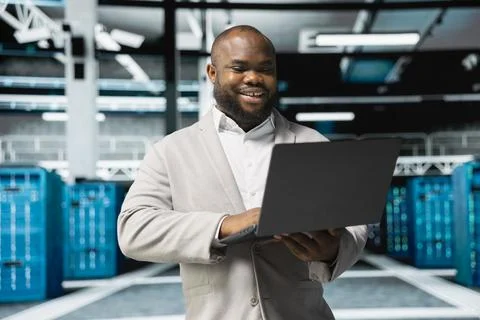 Happy programmer in server farm overseeing mainframes devices 스톡 사진