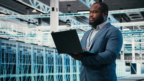 Happy programmer in server hub using laptop to do maintenance tasks Stock Footage 330029078
