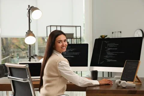 Happy programmer working at desk in office Stock Photos