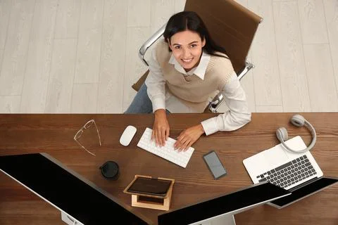 Happy programmer working at desk in office, top view 写真素材