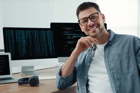 Happy programmer working at desk in office Stock Photos