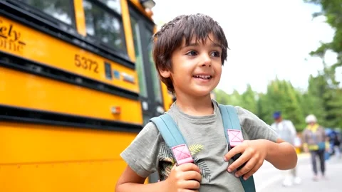 Happy pupil wearing backpack waiting for school bus Stock Footage 315500442