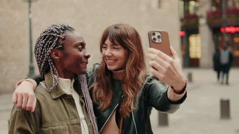 Happy queer couple or two girls on a vacation taking selfie, kissing and Stock Footage 304280434