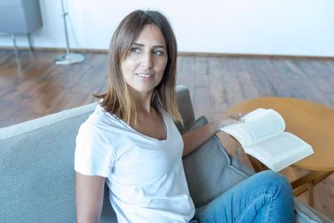 Happy reader reading a book at home Stock Photos