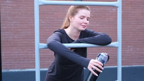 Happy red-haired girl doing fitness workout on a sports ground in a summer Stock Footage 298296725