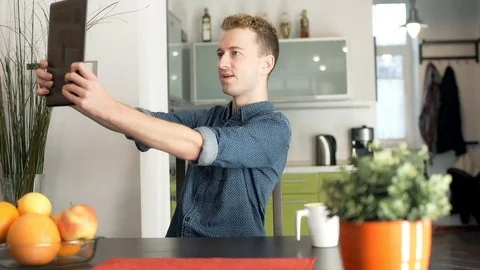 Happy, red haired man doing selfies on tablet at home Stock-Footage 70379929