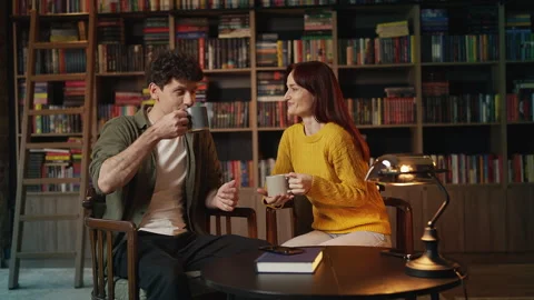 Happy red-haired woman and boyfriend drinking tea and talking in coffee shop Stock Footage 340266816